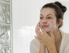 A Woman Applies Facial Cream On Her Face.