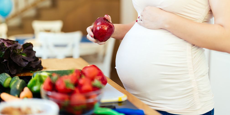A Pregnant Woman Eating Fresh Fruits.