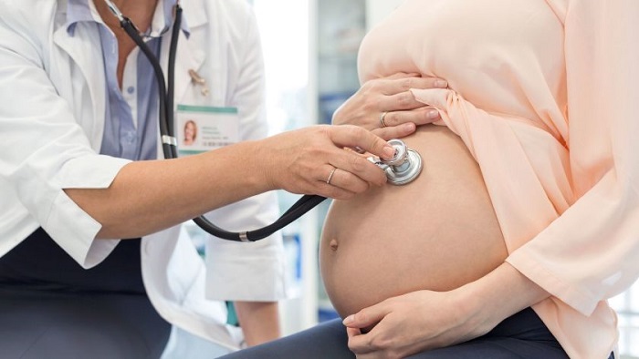 Pregnant Woman Checks By Her Doctor In Clinic.