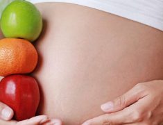 A Pregnant Woman Holding Fruits.