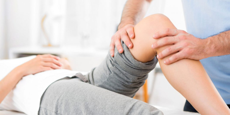 A Physiotherapist Give Knee Massage To A Patient